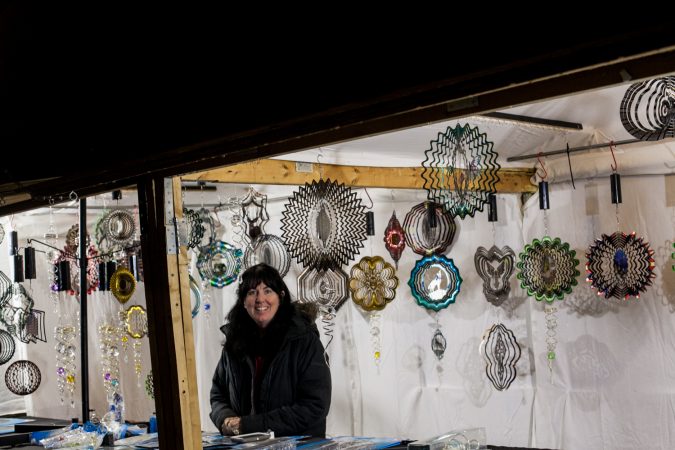 Kristine Santos stands among her wind spinners at her stand 
