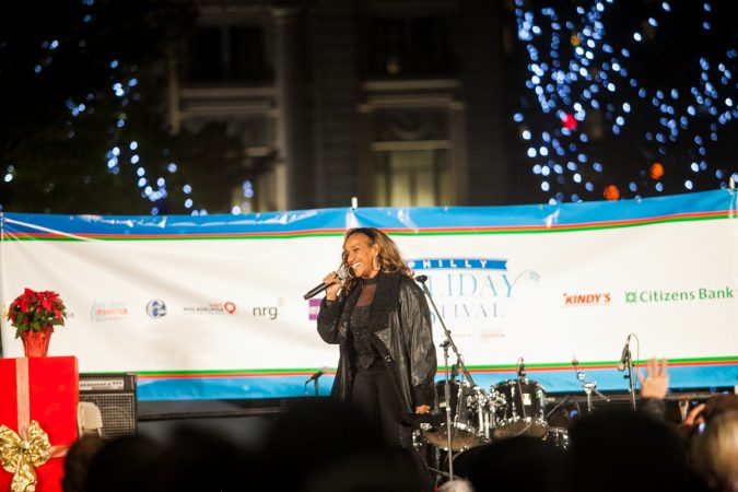 Singer Kathy Sledge performs at the Christmas tree lighting ceremony outside of City Hall Friday. (Brad Larrison for WHYY)
