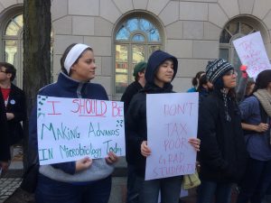 Graduate students from several universities in the Philadelphia region held signs to protest the GOP tax plan in front of U.S. Senator Pat Toomey's office.