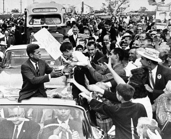 Sen. John F. Kennedy, democratic presidential nominee, reaches out for unidentified youngster held out be enthusiastic father as the senatorís motorcade moved through out cheering crowd at Levittown, NJ., Oct. 16, 1960 this afternoon. Kennedy address throng officially estimated at 20,000 in Levittown, shopping plaza. The crowd interrupted Kennedyís speech with applause when he said he had disagreements with Vice President Nixon. (AP Photo)