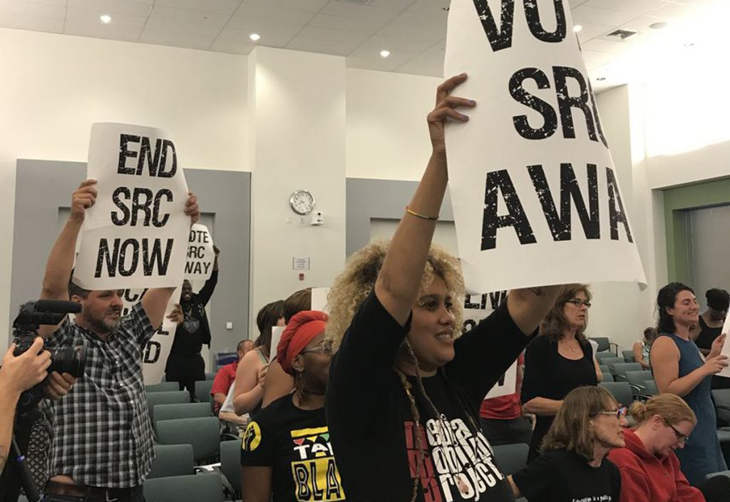 NB-src-meeting-june-15.x1200 At the June 15 School Reform Commission meeting, demonstrators carried signs calling for the SRC to vote itself out of existence and return the school district to city control. (David Hornbeck/The Notebook)