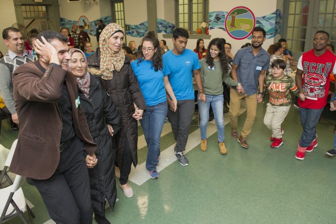 Syrian refugees lead fellow refugees from all parts of the world in a Syrian folk dance. (Jonathan Wilson for WHYY)