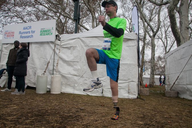 Evan Freiberg warms up before the Rothman Institute 8k Saturday. The 43-year-old is diagnosed with leiomyosarcoma, a form of cancer, and competed after losing the bottom portion of his left leg to the disease. (Brad Larrison for WHYY)