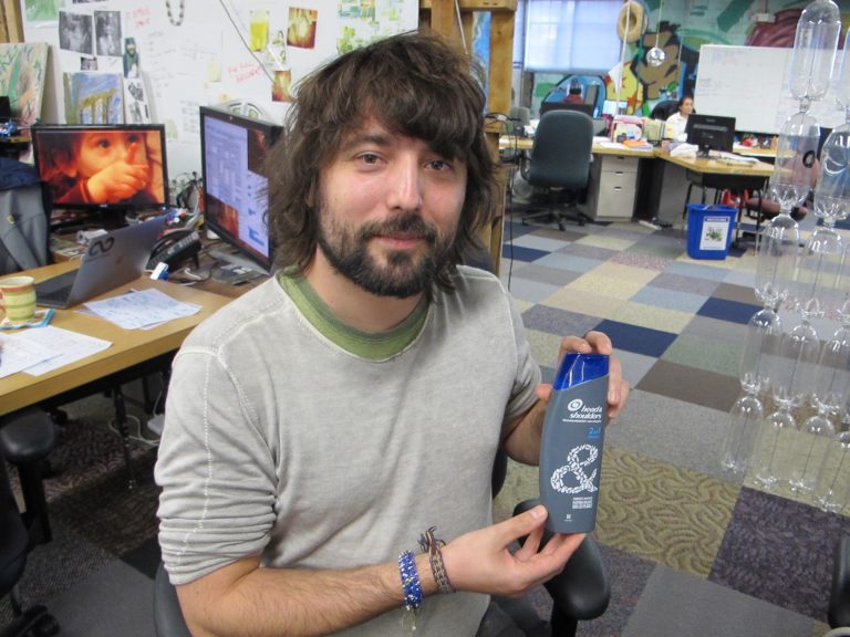 TerraCycle CEO Tom Szaky shows a shampoo bottle made with recycled plastic collected from beaches and oceans. (Phil Gregory/WHYY)