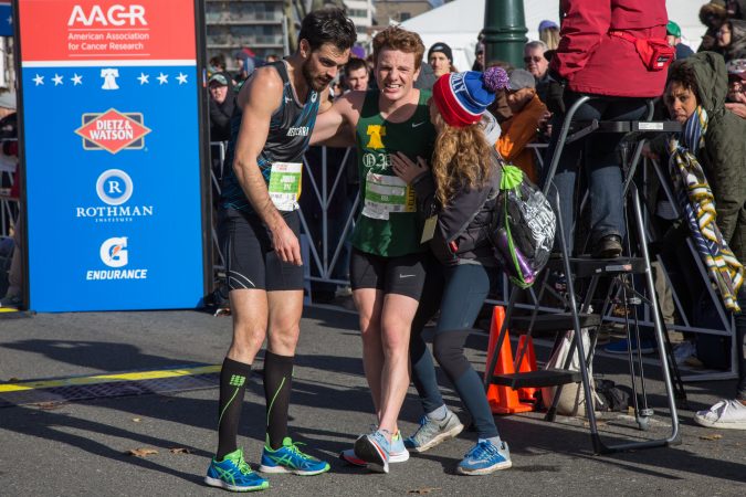 Patrick Richie, 26, center, is helped by his friend Liz Pagonis, and fellow runner, Johan Trimaille, after being the first Philadelphian to cross the finish line at the 23rd annual Philadelphia Marathon on Sunday, November 19th, 2017.