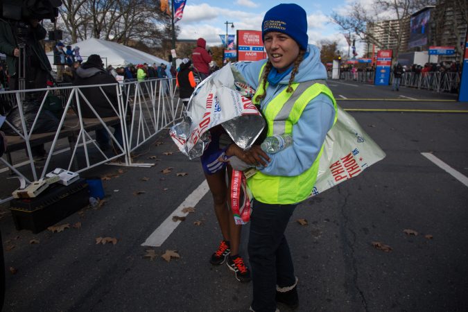 A race volunteer helps an exhausted runner after they completed the marathon.
