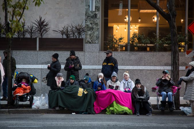 Families tuck in for the wintery morning ahead for the 98th annual Philadelphia Thanksgiving Day Parade, November 23, 2017. (Emily Cohen for WHYY)