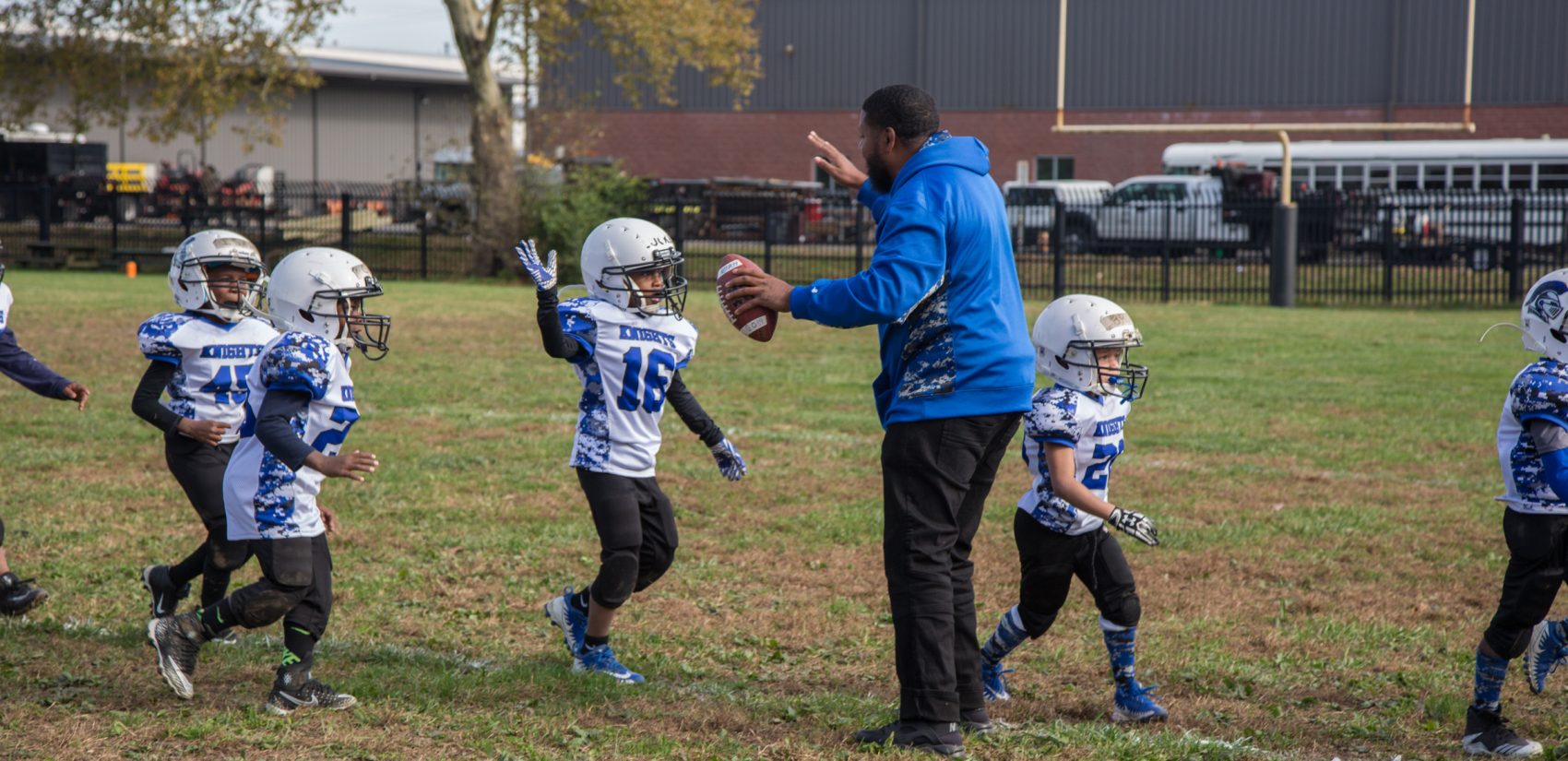 FACT graduate Rickey Duncan high-fives his players as the come off the field for halftime.