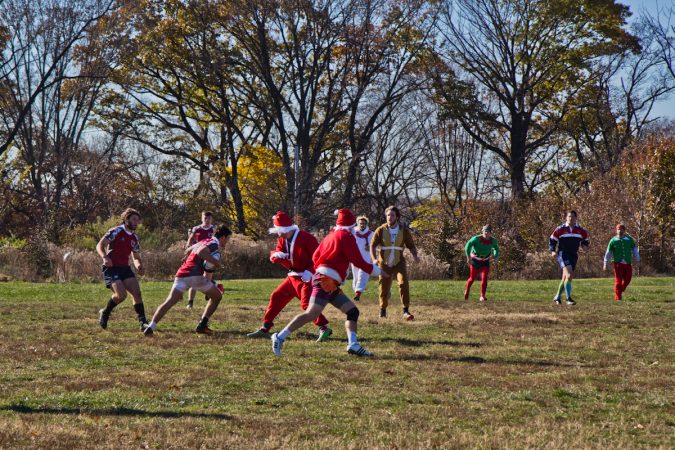 Prep 14 battle the Sexy Santas at the Apple Pie 7s Rugby Tournament in Fairmount Park. (Kimberly Paynter/WHYY)