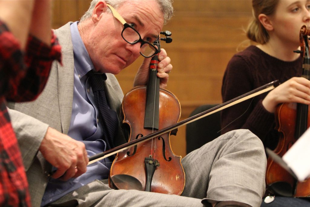 John McInerney plays a one-string violin during a rehearsal for Symphony for Broken Orchestra at the Curtis Center