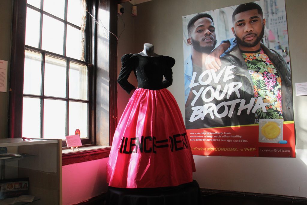 The SILENCE=DEATH gown worn by activist Dominic Bash stands beside a 2017 poster in the William Way exhibit documenting Philadelphia's battle against AIDS