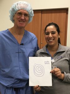 Dr. Gordon Baltuch and nurse practitioner Hanane Chaibainou pose with the final example of Neyhart's tremor suppression: a drawing of a spiral.
