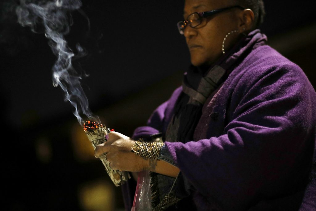 Erricka Bridgeford In this Dec. 11, 2017 photo, Erricka Bridgeford burns sage as she performs a ceremony near the scene of a homicide in Baltimore. Bridgeford lost a brother, a stepson, and three cousins to gun violence. (Patrick Semansky/AP Photo)