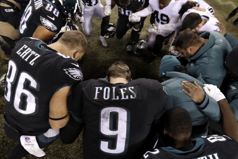 Philadelphia Eagles' Nick Foles (9) kneels with other players after an NFL football game against the Oakland Raiders, Monday, Dec. 25, 2017, in Philadelphia. Philadelphia won 19-10. (Michael Perez/AP Photo)
