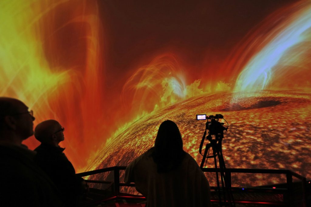 New Planetarium In this Wednesday, Dec. 6, 2017 photo, people watch interstellar bodies move through space during a media preview at the planetarium at Liberty Science Center in Jersey City, N.J. The newly refurbished planetarium is the largest in the western hemisphere and uses ten advanced projectors to produce an 8K resolution. It opens to the public on Saturday, Dec. 9, 2017. (Seth Wenig/AP Photo)