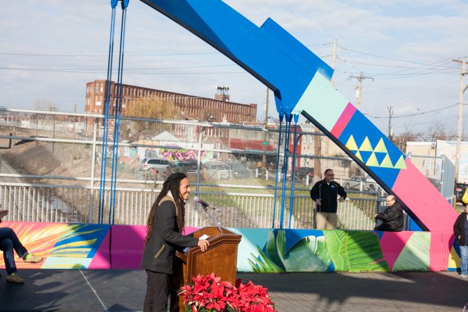Lead artist Calo Rosa spoke at the dedication ceremony for the recently completed mural on the B Street Bridge in Kensington. (Brad Larrison for WHYY)