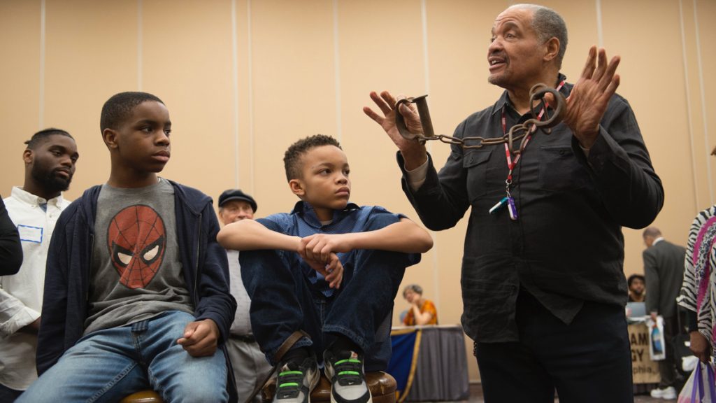 Eastwood_20170416BlackHistoryCultureShowcase00012 J. Justin Ragsdale holds up antique slave shackles during a demonstration on the conditions inside slave ships during the 2017 Black History and Culture Showcase in Philadelphia