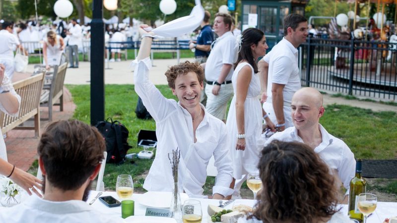 Keith Grabowski waves his napkin before dinner at Diner en Blanc  in Franklin Square on August 17, 2017. (Brad Larrison for NewsWorks)
