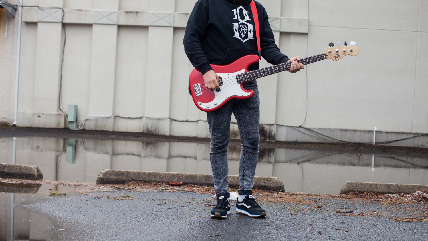 Viktor, an undocumented immigrant from Belarus seeking asylum in the U.S, strums a bass guitar. He left Belarus with a bandmate and hopes to play music again if he is able to attain legal status.