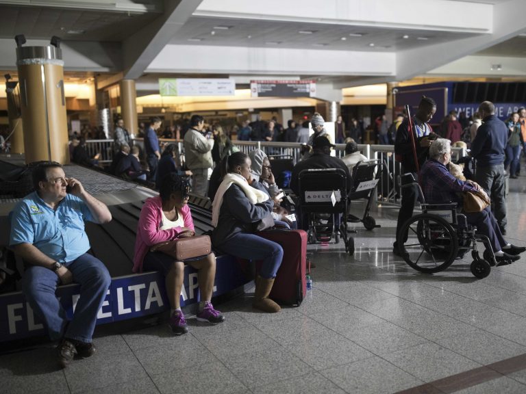 Passengers wait after the lights went out at Hartfield-Jackson Atlanta International Airport on Sunday. Many travelers were stuck in grounded planes for hours.