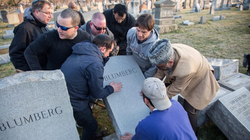Members from the local Jewish community are joined by members of the Philadelphia chapter of the Ahmadiyya Muslim Center and others as they try to put upright headstones that were vandalized at Mount Carmel Jewish Cemetary in Northeast Philadelphia. The vandalism was seen as part of a growing trend of anti-semitism sweeping the United States. More than 500 headstones were toppled and broken overnight February 26, 2017. (Emily Cohen for NewsWorks)
