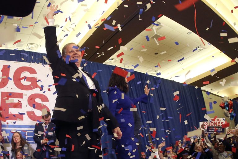 Democrat Doug Jones and his wife Louise wave to supporters