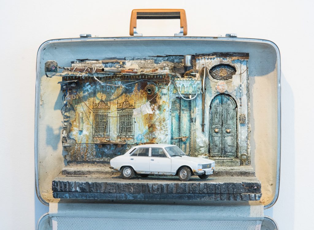 The white Peugeot 405, the vehicle of choice for the Syrian secret police, is parked outside a home in Damascus. In the diorama’s upper left corner hangs a camera, suggesting surveillance. The white Peugeot 405, the vehicle of choice for the Syrian secret police, is parked outside a home in Damascus. In the diorama's upper left corner hangs a camera, suggesting surveillance.
(Rodney Nelson)