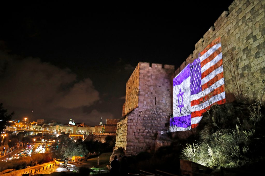The American and Israeli flags are on display Wednesday on the walls of the Old City of Jerusalem. President Trump announced that the U.S. will view Jerusalem as the capital of Israel, and he ordered the State Department to 