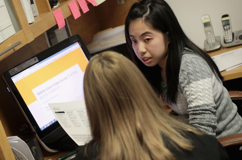 Kelley Mui helps a client sign up for health insurance through the Affordable Care Act on Dec. 15 at the Midwest Asian Health Association in Chicago.