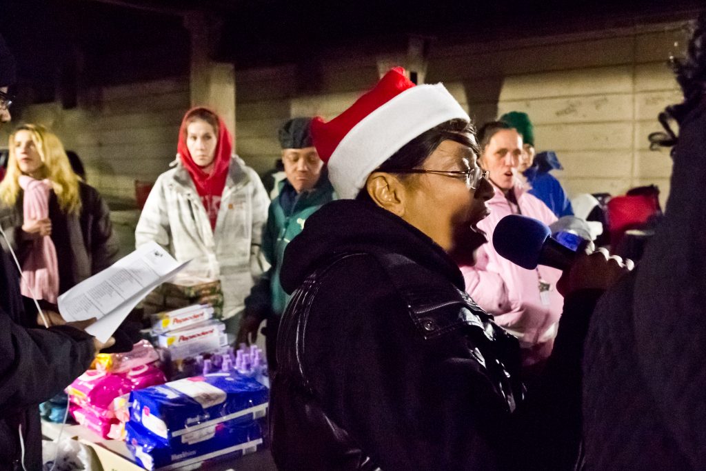 kenzo carols Asteria Vives, head of Home Quarters and Friends, sings carols at the Emerald Street and Lehigh underpass, in the Kensington section of Philadelphia. (Kimberly Paynter/WHYY)