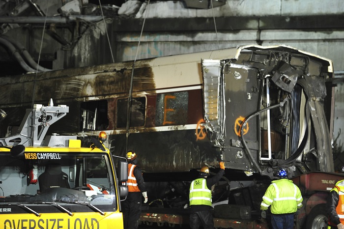 Train Derailment Washington State A damaged Amtrak passenger train car is lifted from the tracks at the site of the derailment of an Amtrak train in Dupont, Wash., Tuesday, Dec. 19, 2017. Investigators are looking into whether the Amtrak engineer whose speeding train plunged off an overpass on Monday, killing several people, was distracted by the presence of an employee-in-training next to him in the locomotive, a federal official said Tuesday. (Thomas James/Pool via AP)