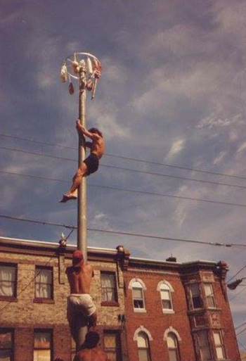 Frank Longo nears the top of the pole in the 1993 competition at the Italian Market Festival.