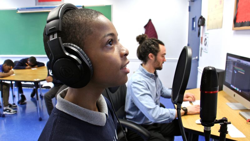 Eugene Bull records his rap while other students work on their lyrics in Luke O'Brien's classroom at Camelot KAPS Alternative School. (Emma Lee/WHYY)