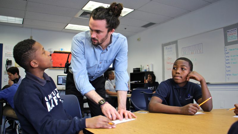 Jeremiah Johnson (left) works on his rap lyric with counselor Luke O'Brien while Ahmad Jackson (right) looks on. (Emma Lee/WHYY)