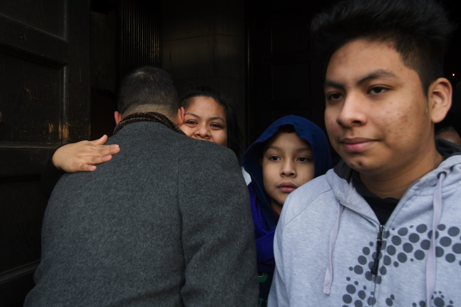State Rep. Chris Rabb and Camela Apolonio Hernandez embrace in the doorway of Church of the Advocate in North Philadelphia as her four children leave sanctuary to go back to school for the first time since the family received a deportation order.