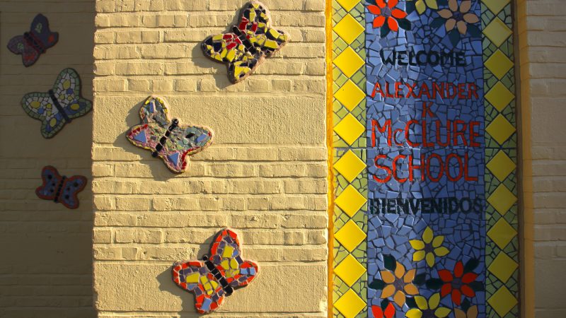 A five-year mural project covers the facade of the McClure School in North Philadelphia with colorful mosaics designed by students.