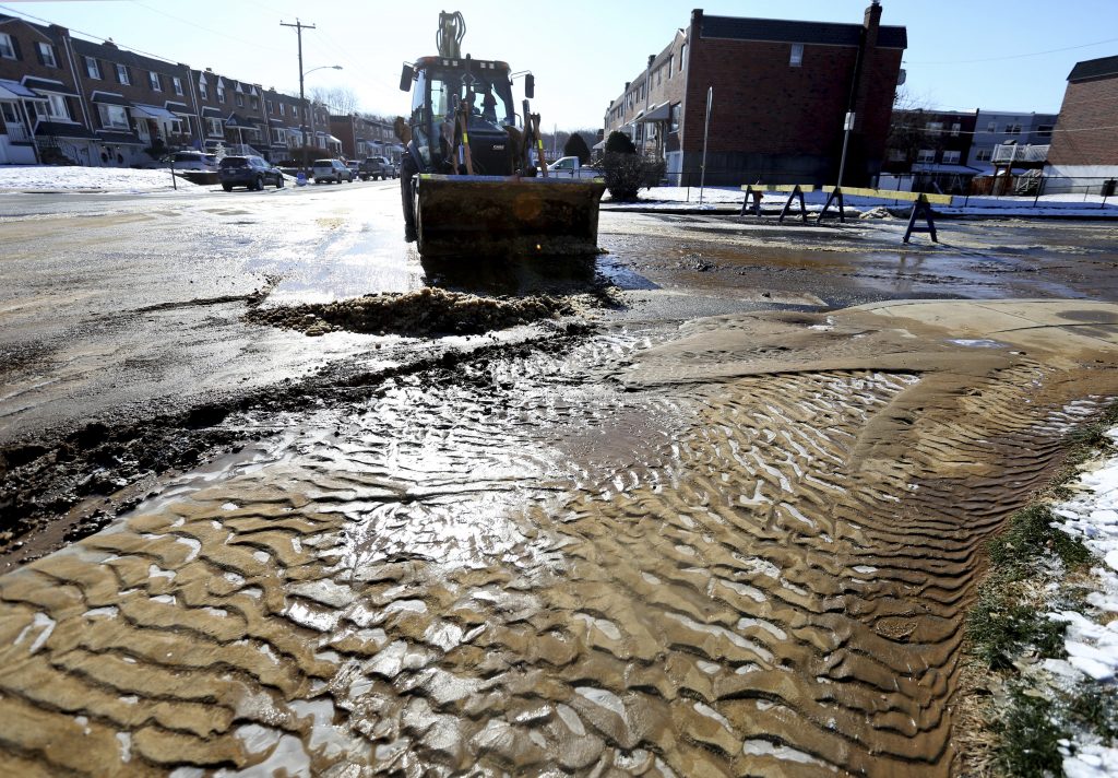 Mud and ice are cleared from the road during cleanup after a water main break last week in Northeast Philadelphia. City workers are dealing with about 20 water main breaks a day, officials say.