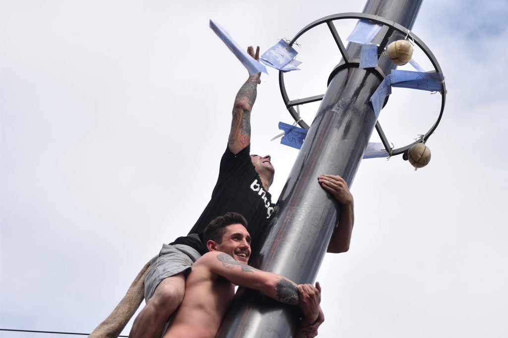 ItalianMarketFestival2017_CreditKathrineKuo_1179 Competitors in the greased pole challenge at the Italian Market Festival reach the prizes at the top.