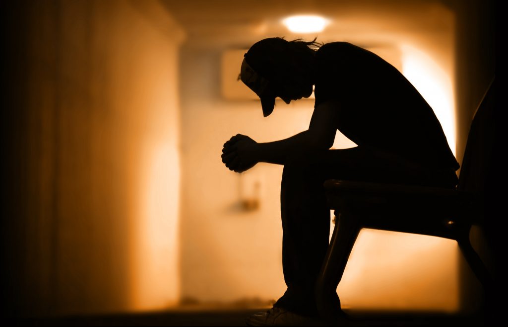 Desperate Young man with hands clasped together praying