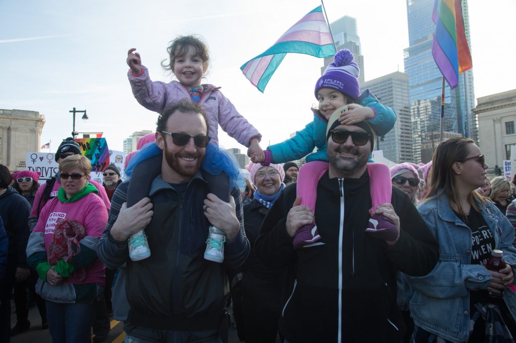 cohen-womens_march_2018-9 Josh Gordon (from left) holds 3-year-old Cece while she holds hands with her best friend, Reva, carried by her father, Demitry, at the 2018 Womens March on Philadelphia in January. (Emily Cohen for WHYY)