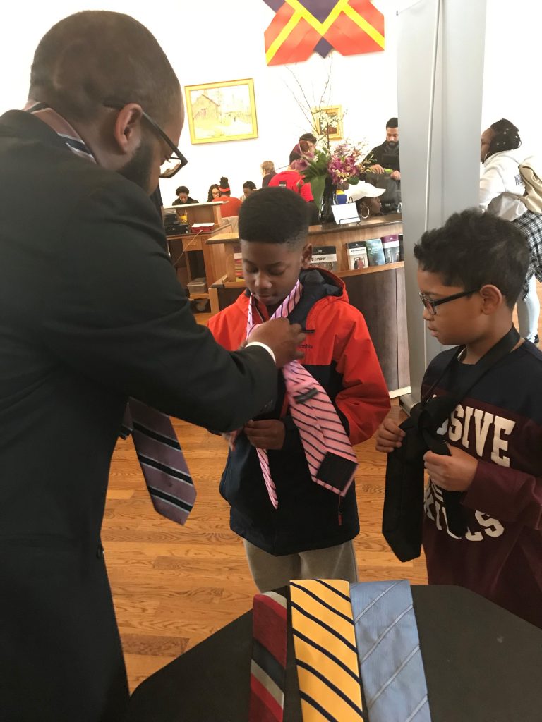 king ties William Merritt Jr. teaches boys how to fix a tie during MLK Day of Service event. (Nichelle Polston/WHYY)