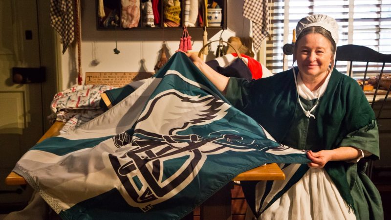A Betsy Ross re-enactor sews an Eagles flag the Monday before the Philadelphia football team heads to the Super Bowl. (Kimberly Paynter/WHYY)