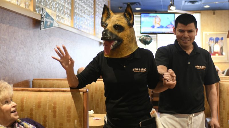 In an “underdog” mask, Kathy Ryder greets patrons at Ben & Irvs Restaurant in Huntingdon Valley, Pennsylvania, on Thursday. (Bastiaan Slabbers for WHYY)