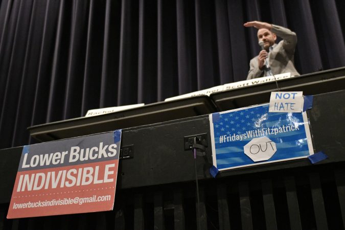 Signs mounted on the edge of the stage during a candidate forum with Democratic candidates for the newly-drawn 1st Congressional District at a candidate forum in Newtown, Pa. on Tuesday evening. (Bastiaan Slabbers/for WHYY)