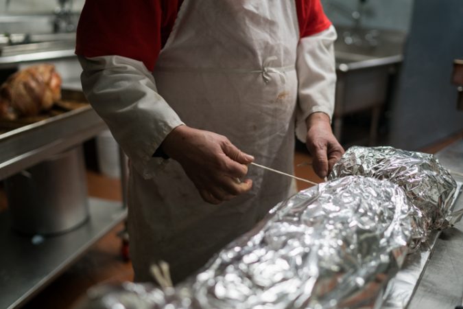 Sid Dk packages pork at Esposito’s Porchetta in South Philadelphia before the Super Bowl on January 4, 2018. (Branden Eastwood for WHYY)