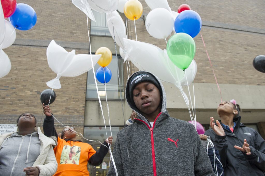 Erase-Rate-01 Alan Williams, whose aunt was murdered, cries as balloons honoring murder victims are released. (Jonathan Wilson for WHYY)