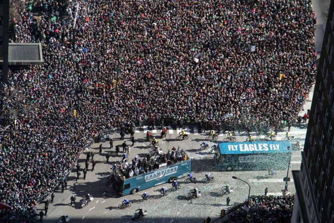 The Eagles turn the corner onto the Ben Franklin Parkway where thousands of fans have gathered for the Super Bowl parade. (Emma Lee/WHYY)