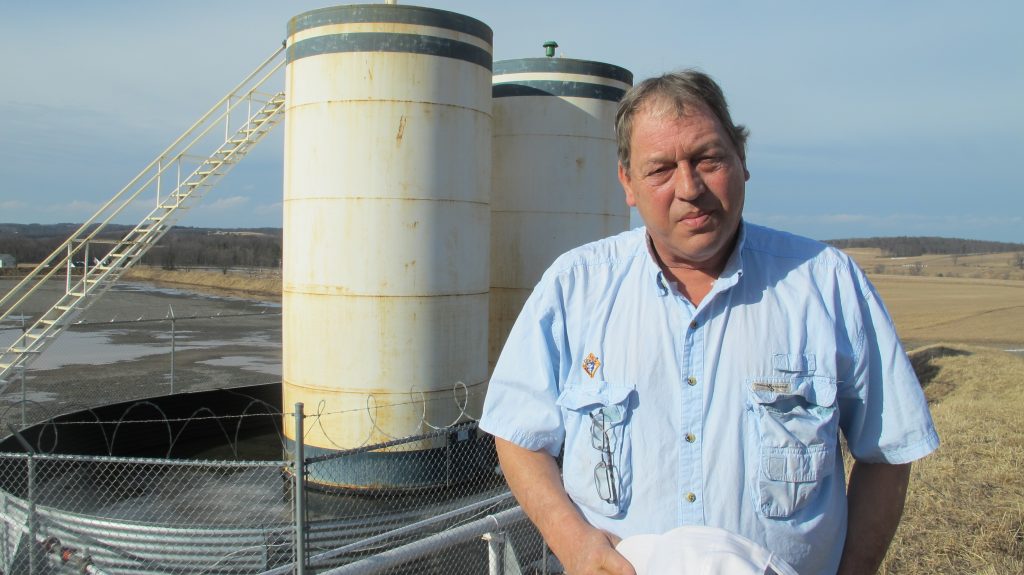 Jim Barrett stands next to a wellpad on his farm in Bradford County. He says Chesapeake Energy, which drilled four natural gas wells on his land, is cheating him out of royalty money. (Marie Cusick/StateImpact Pennsylvania)