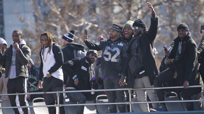 Eagles teamates atop parade bus. (Jonathan Wilson for WHYY)