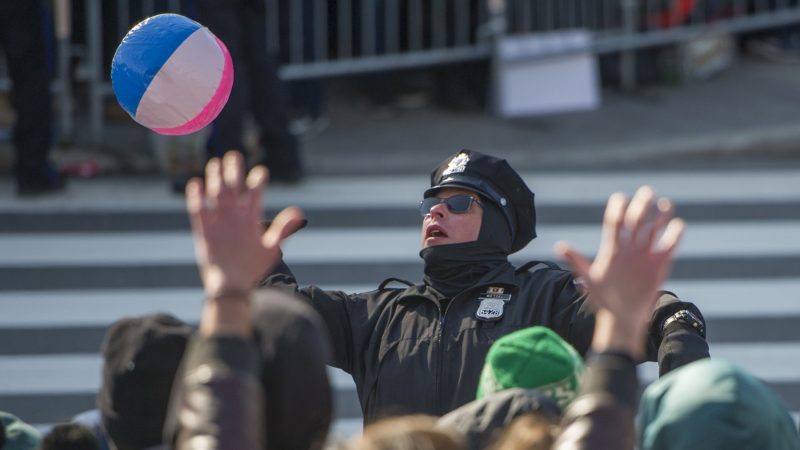 A police officer passes a beach ball back to the crowd. (Jonathan Wilson for WHYY)